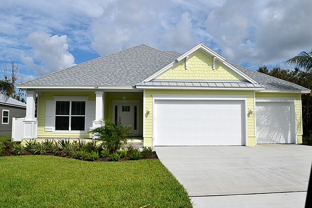 The same home after soft washing — clean roof, bright siding and the rust gone from the driveway